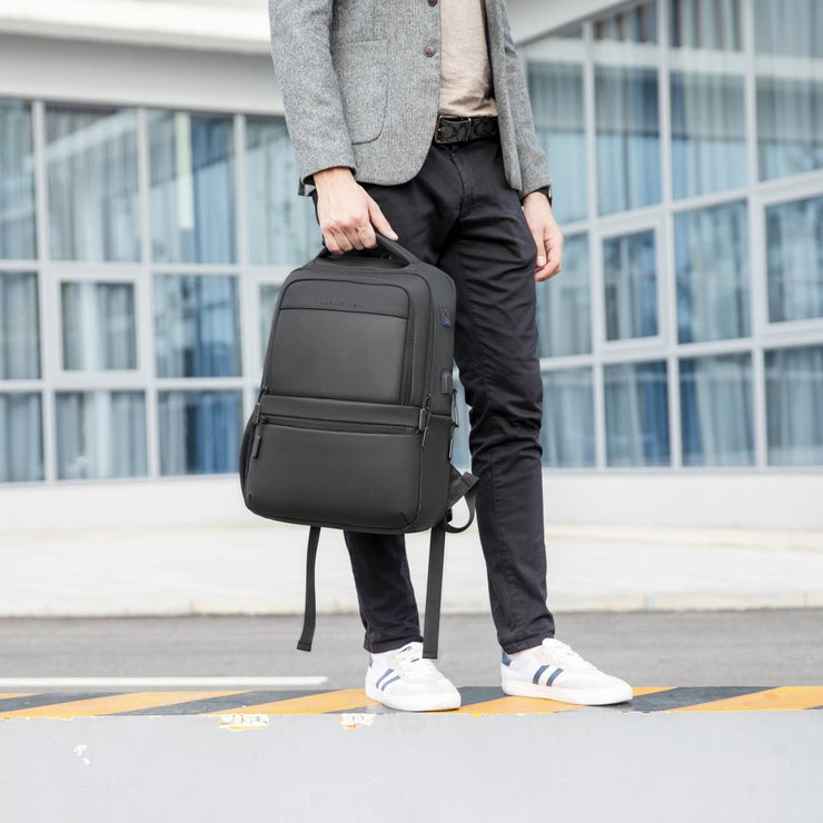 business traveler holding black backpack